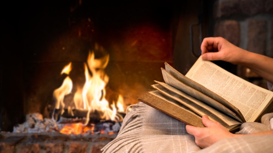 reading book by fireplace