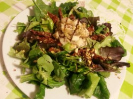 Insalata con pesce spada, foglie verdi , pomodori secchi e pistacchio