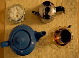 Teiera in ceramica, zollette zucchero, bollitore e tazza da té: una pausa té speciale