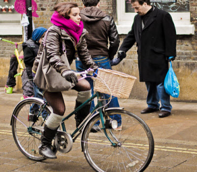 Ragazza in bici con sciarpa e guanti per sfidando il grande freddo