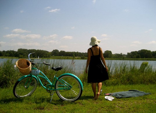 Donna e bicicletta sulle rive di un fiume