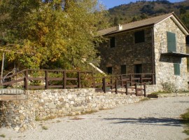 Esterno dell'Ecobnb Centro Anidra, in Liguria. Struttura in pietra, tetto a spiovente e staccionata