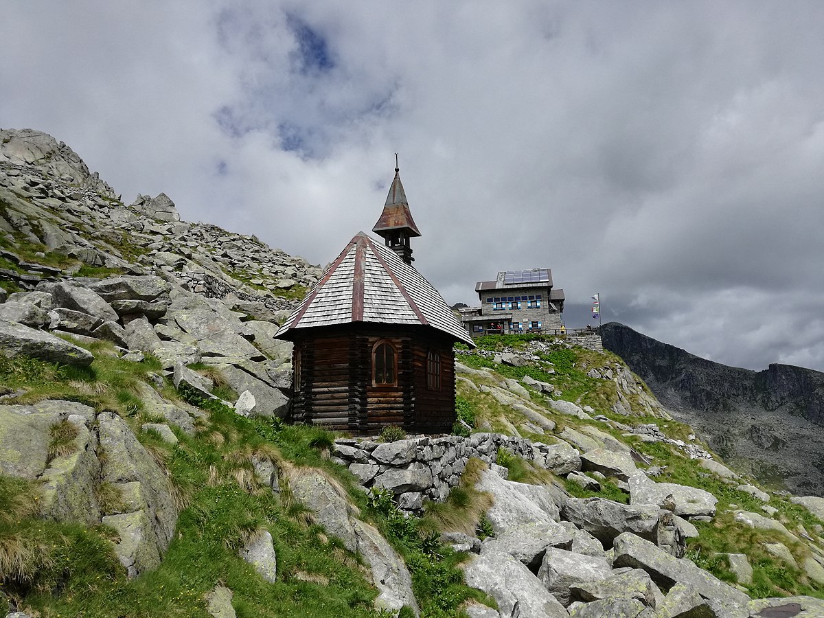 Una chiesetta alpina e sullo sfondo il rifugio Carè Alto, via Wikipedia commons