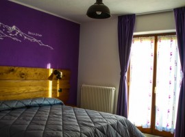 stanza con parete viola e arredi legno