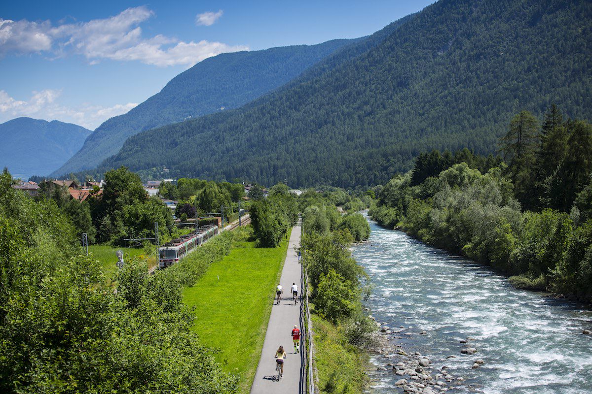 ciclabile con da una parte il treno e dall'altra il fiume noce