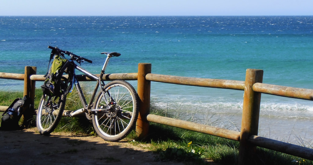 Una biciletta adagiata sulla staccionata che divide la terraferma dal mare