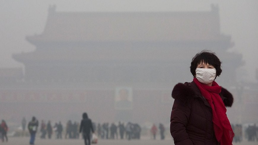 Turista con mascherina a Pechino, città inospitale per lo smog