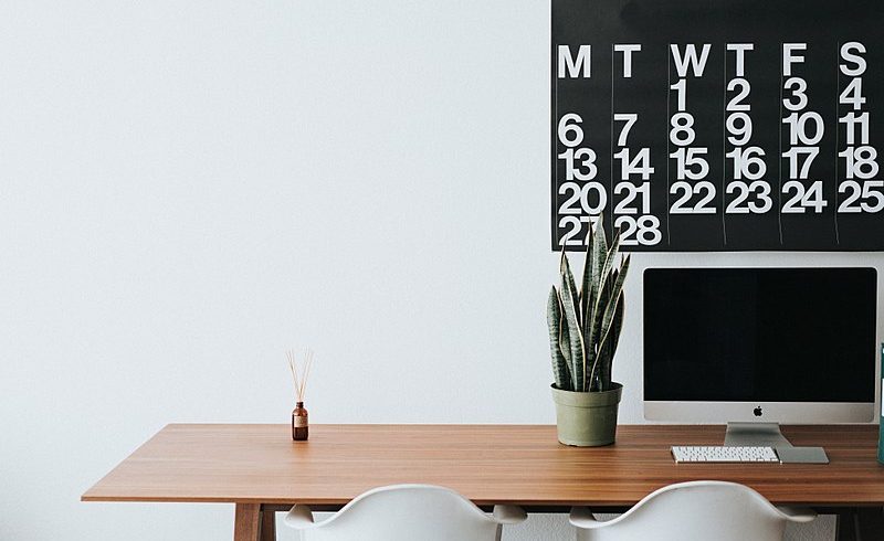 Ufficio minimalista con scrivania di legno e calendario