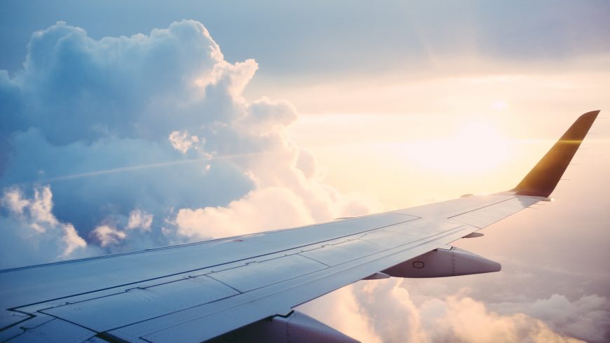 Aereo in volo, uno dei mezzi di trasporto con il maggiore impatto climatico