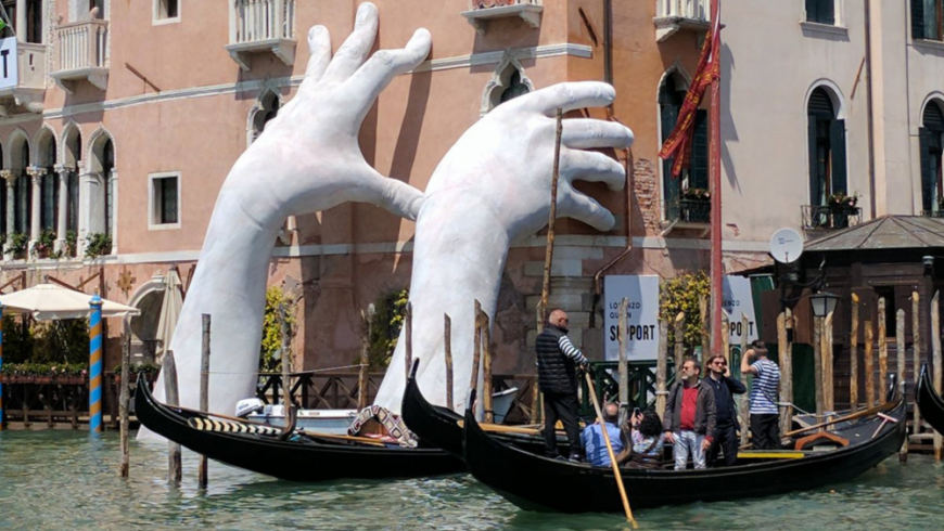 opera d'arte, mani in cemento che sorreggono uno degli edifici piú antichi di Venezia
