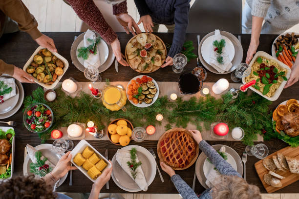 Pranzo in famiglia il giorno di Natale che tengono piatti con porzioni moderate e dolci fatti in casa.