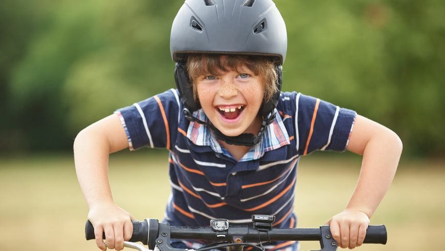Bambino con il casco in bicicletta