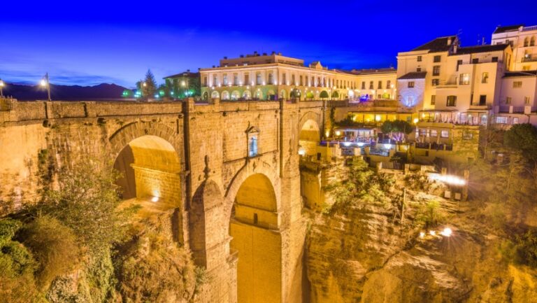 El pueblo de Ronda, iluminado durante la noche. El Puente Nuevo une los dos lados del Cañón del Tajo