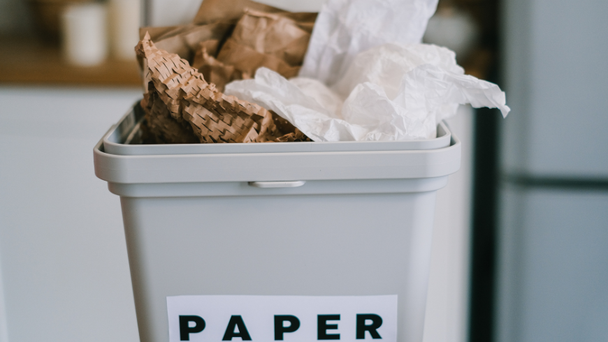 Bidone della raccolta differenziata per carta e cartone, con giornali e scatole pronte al riciclo