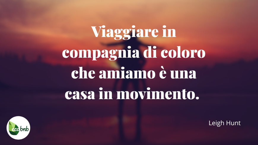 “Viaggiare in compagnia di coloro che amiamo è una casa in movimento". Due persone al tramonto: un ragazzo tiene in braccio una ragazza, condividendo un momento romantico e pieno di leggerezza.