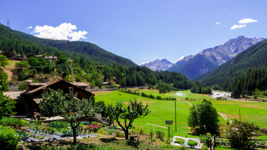 casa di montagna con prato e montagne intorno
