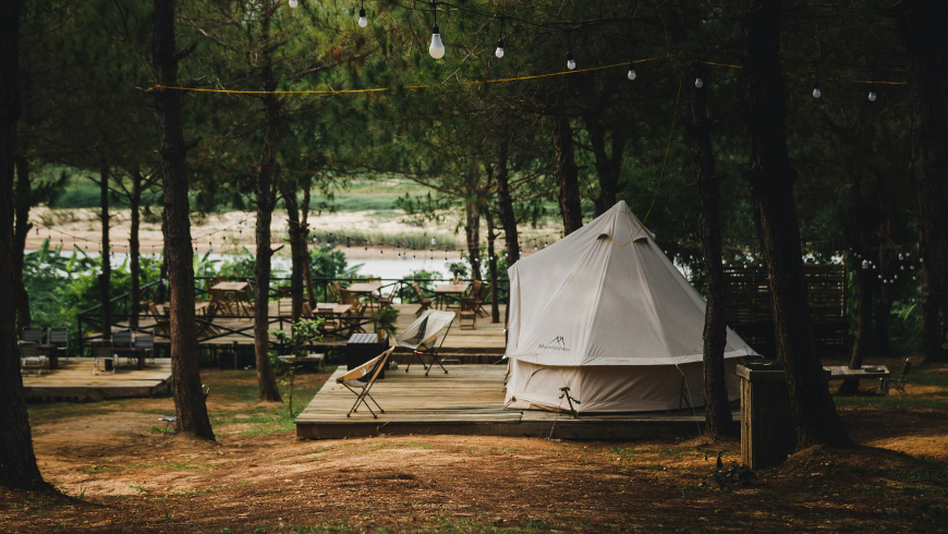 Glamping tent in forest surrounded by trees and nature