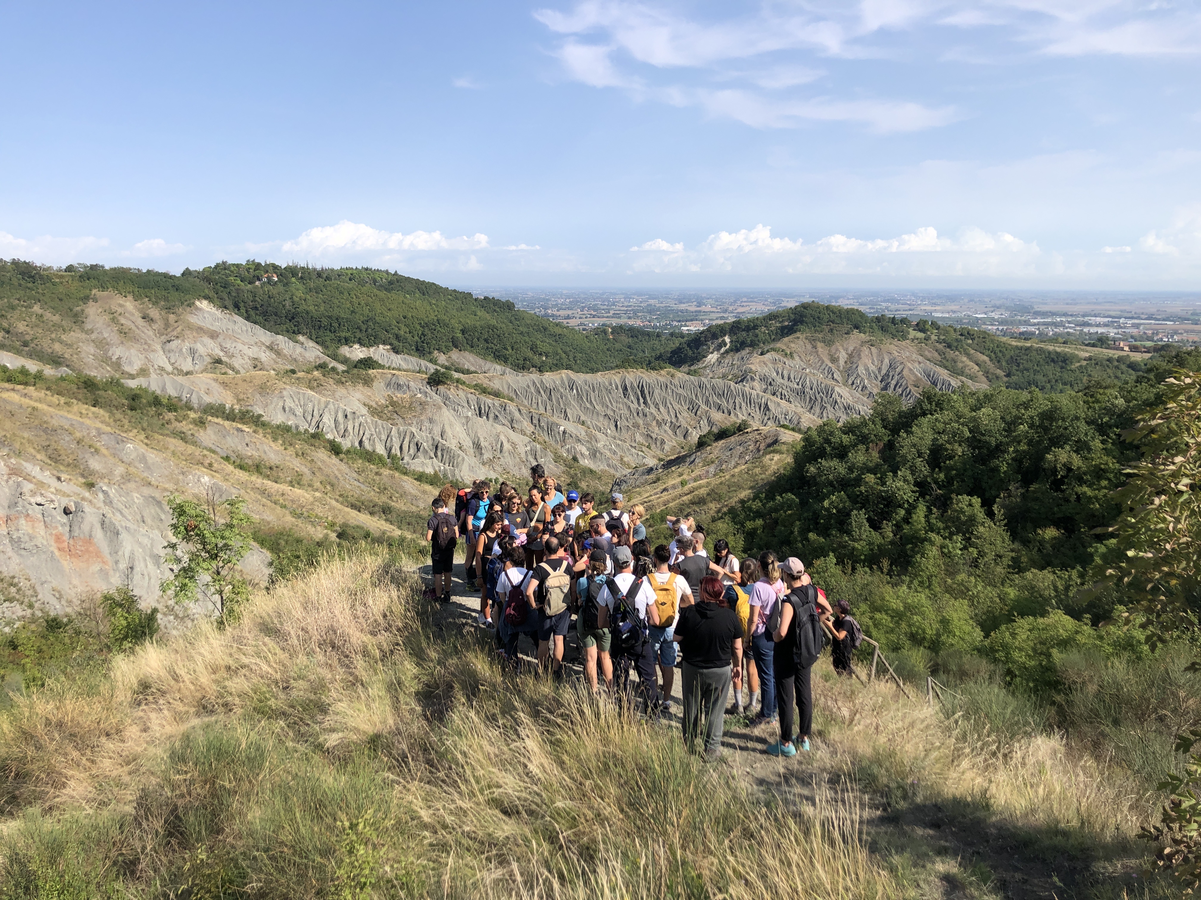 Persone che camminano lungo le colline emiliane tra la natura
