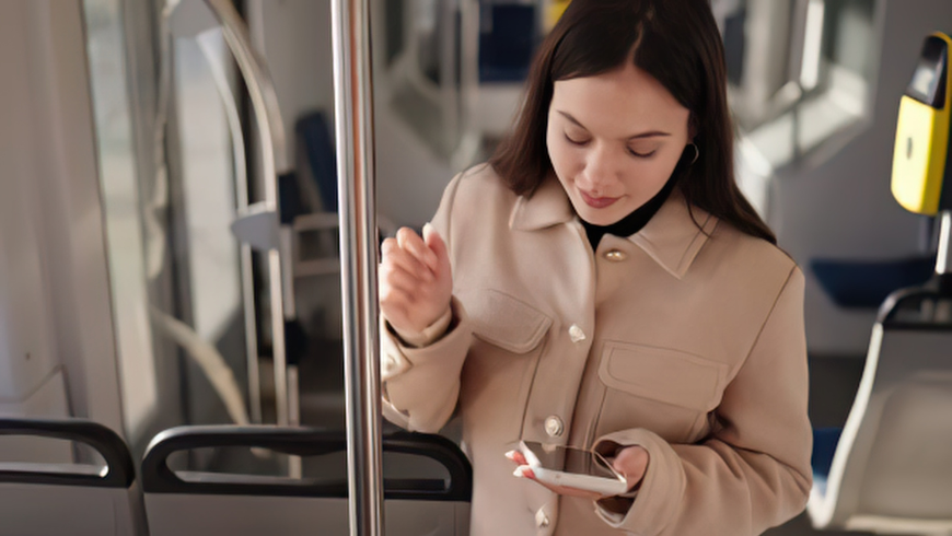 Ragazza su un autobus a Helsinki mentre guarda il cellulare