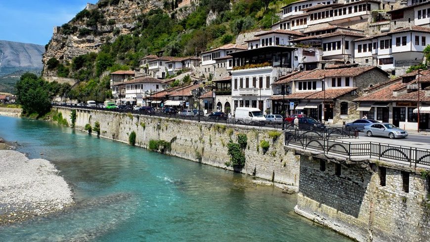Berat, dove il fiume Osum scorre ai piedi dello storico quartiere ottomano. La città è collegata a Tirana da frequenti autobus di linea.