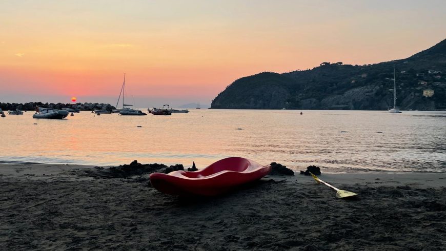 Canoa sulla spiaggia con tramonto
