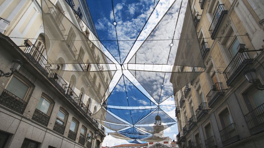 Grande tenda ombreggiante sospesa sopra una strada di Madrid durante l'estate