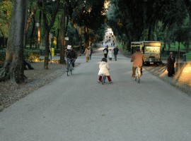 Long boulevard in Villa Borghese Rome, people biking
