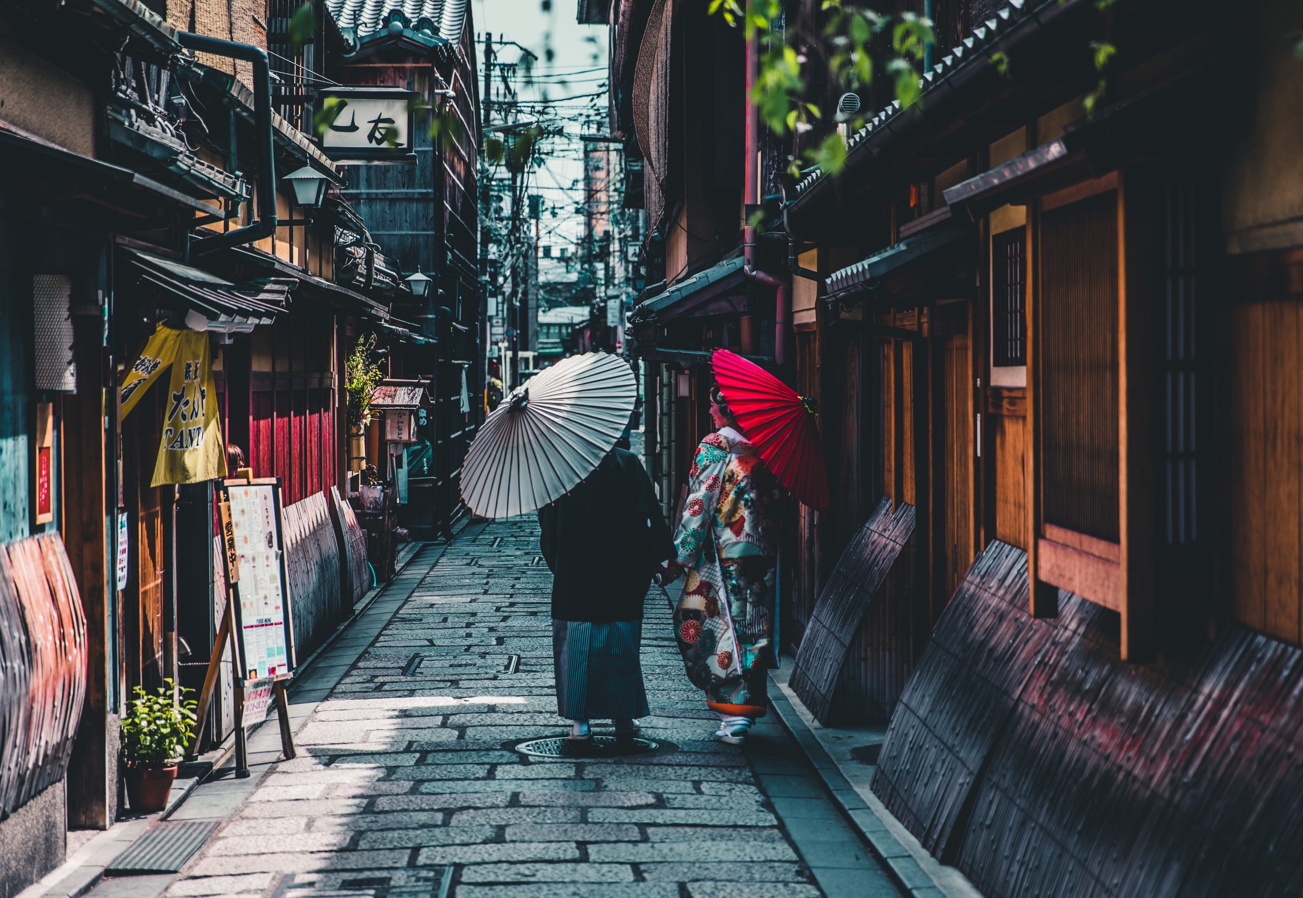 two women in traditional clothing in a historic alley in Asia, example of sustainable cultural tourism