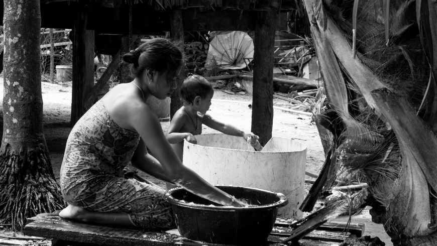 woman and child preparing local food in Asia, example of sustainable tourism supporting local traditions and communities