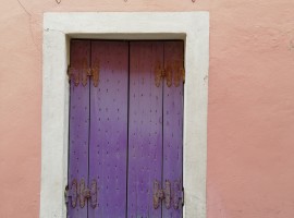 detail of a violet window in a pink house