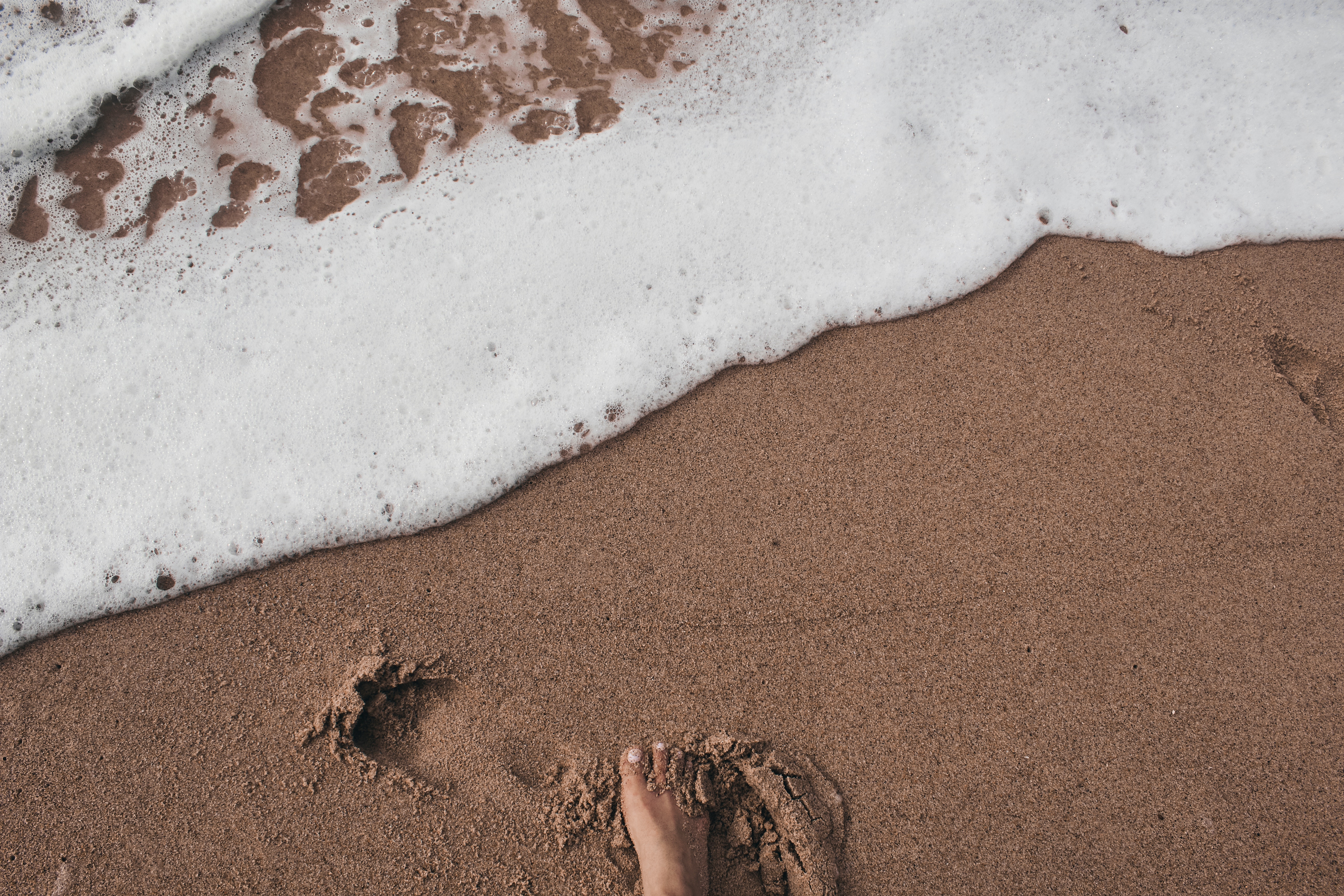 footprint on the sand. sustainable travelling is important.