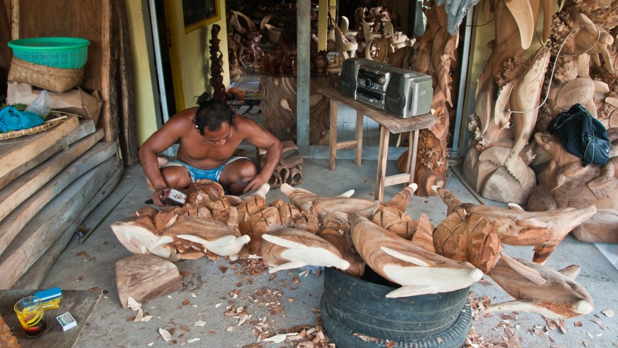 Local man working on a statue from wood.