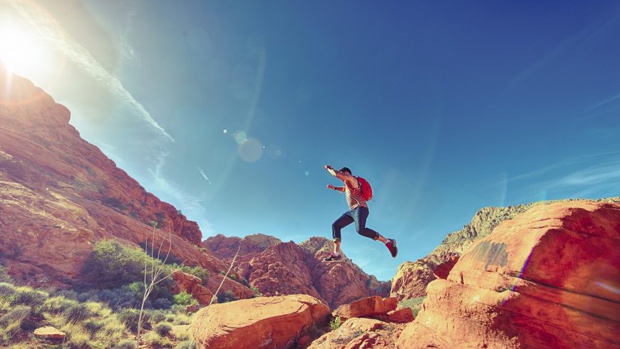 Man jumping on rocks on a hike