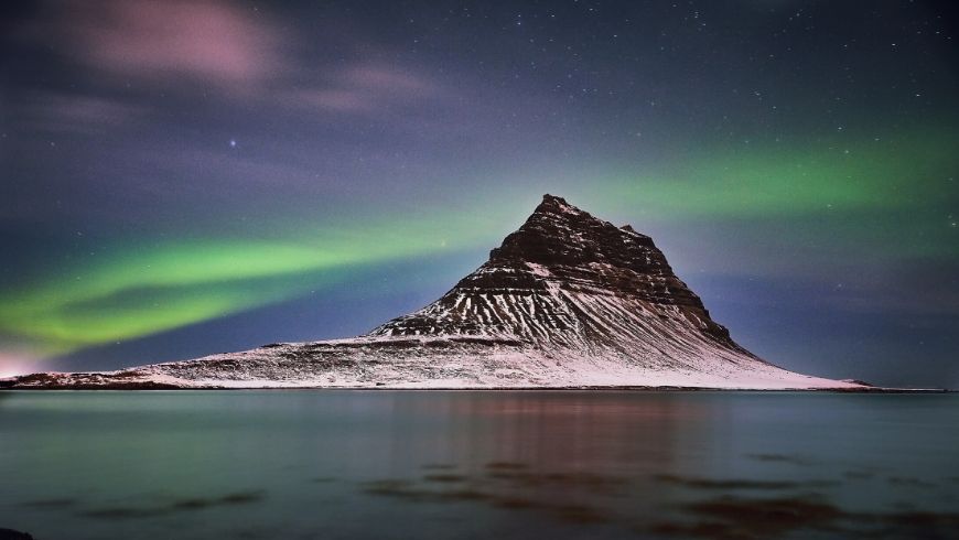 northern lights in iceland around a mountain