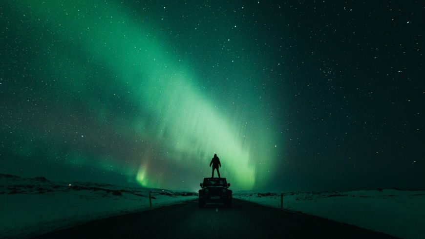 man standing in front of northern lights