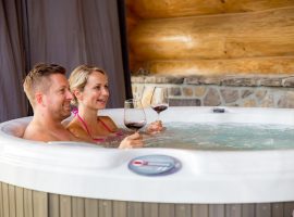 Couple tasting wine in the hot tub