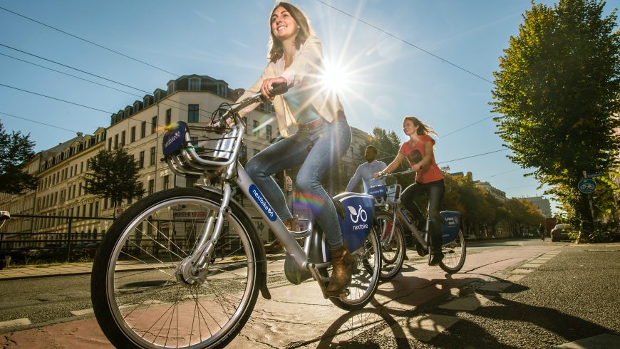 Traveler exploring a city by bicycle, enjoying a sustainable and eco-friendly way to discover local streets and attractions.