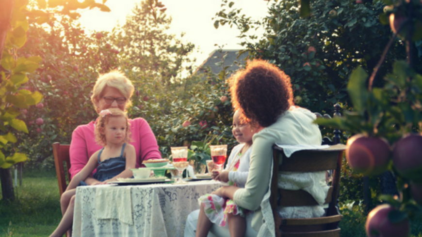 two children with two women sitting near a table laughing