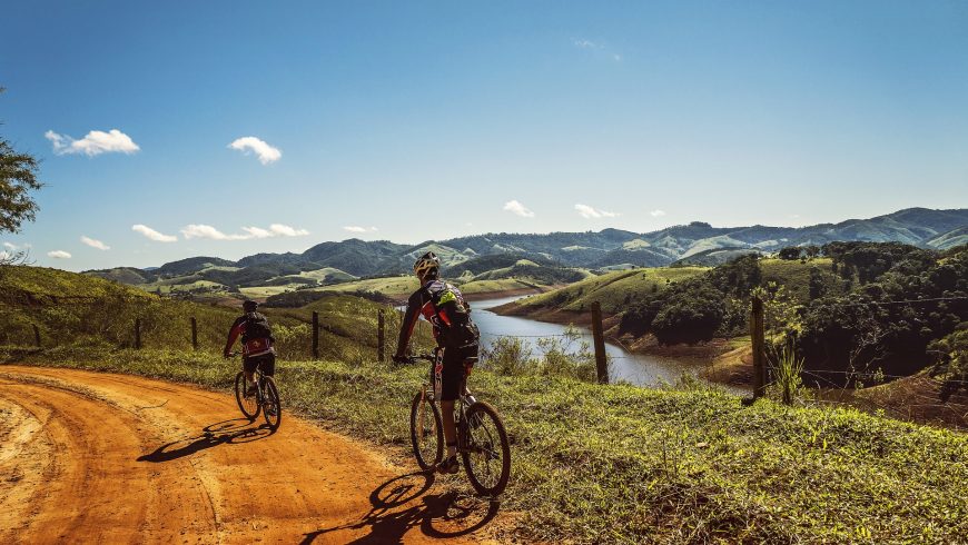 Principles of slow travel (explore the black roads). There are Two cyclists on a road