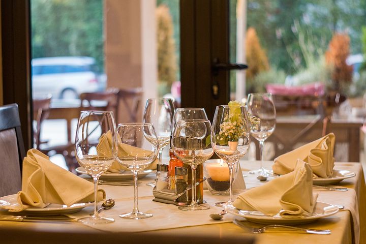 A table of a restaurant set with cloth napkins.