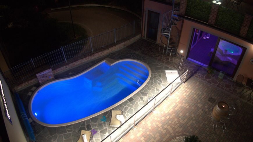 The new swimming pool with water heated by solar panels, seen at night
