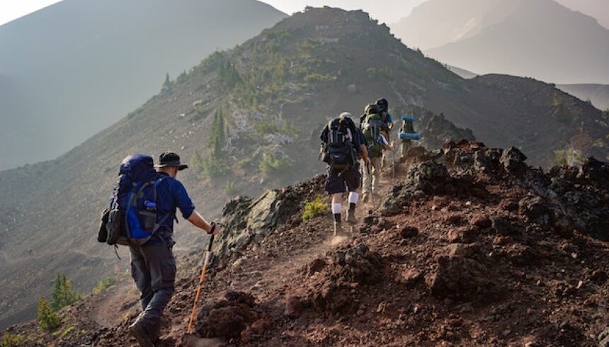 Group of people hiking in the mountains and talking about how to explore a new place while leaving no trace.