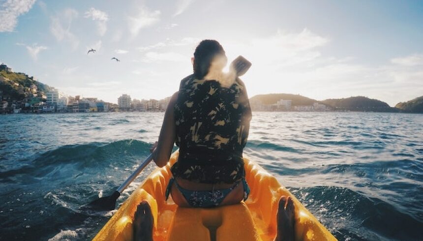 Woman wearing floral vest enjoying a ride on a boat.