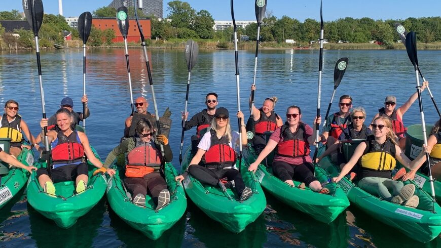 Volunteers in their green kayaks happy in the water