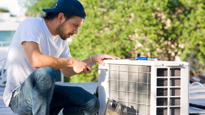 A technician while he is working with a heat pump