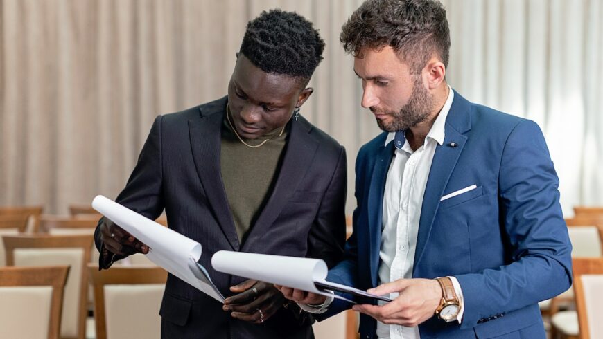 Two people holding legal pads and inspecting their paperwork