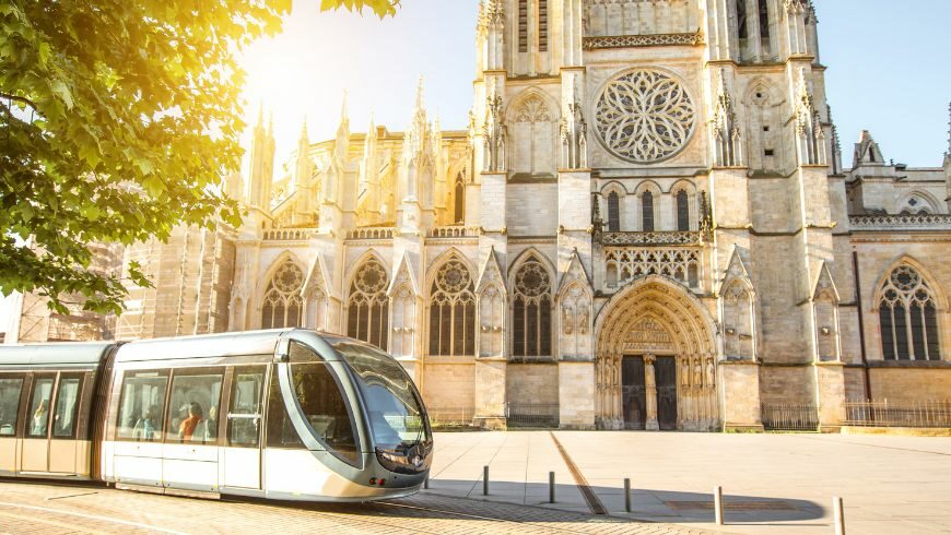 Electric tram in Bordeaux with a cathedral on the background