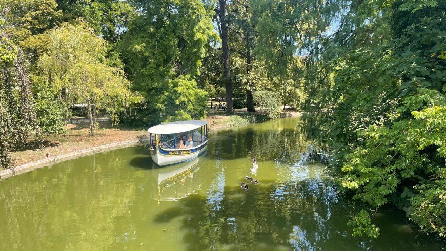 Jardin Public, park in Bordeaux with a little boat cruising on the river Garonne