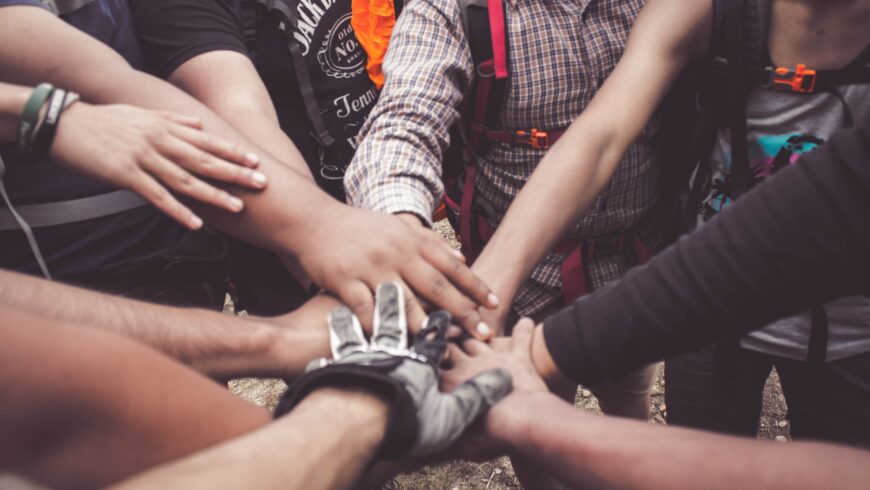 Group of backpackers joining hands