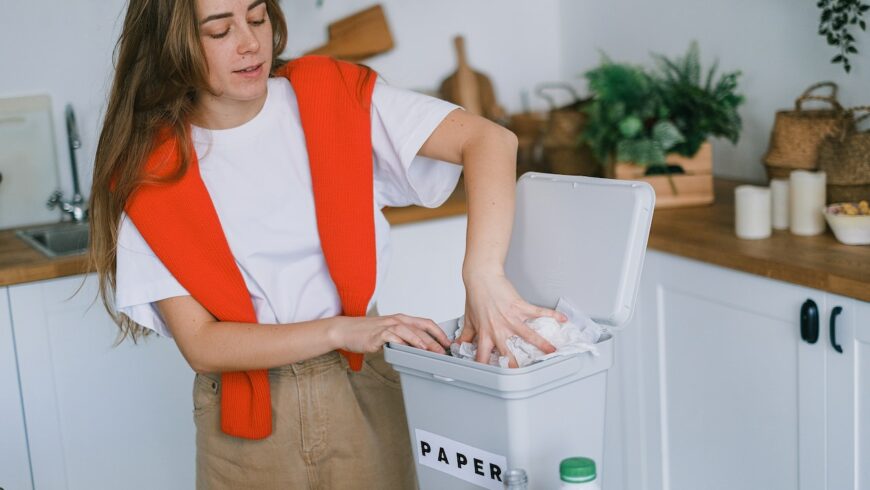 Woman separating trash for recycling at home